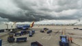 Dramatic Storm clouds hang over gate at airport as plane sits on tarmac Royalty Free Stock Photo