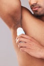 Deodorant, health and man cleaning armpit for wellness, skin and care for body against a grey studio background