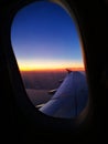 Departing during a sunset orange horizon and a plane wing view