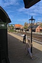 View on the perron with traditionally dressed dutch train guard with signal sign