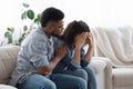 Dependent Relationship. Young Black Guy Soothing His Depressed Girlfriend At Home