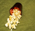 Popcorn in a glass on a green background.