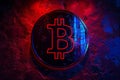 Depicting a the bitcoin logo on the illuminated background with red and blue gradient colors, dark background Royalty Free Stock Photo