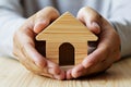 Depicting Home Insurance Protection Hands Cradling A Wooden Toy House