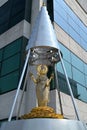 Depiction of Hindu goddess Lakshmi as an elegant, golden-colored woman standing on a lotus in a pyramidal shrine, Bangkok