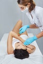 Depilation and epilation female arm with liquid sugar paste. Hand of cosmetologist applying wax paste on armpit. Royalty Free Stock Photo