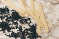 depilatory pearly blue solid wax beans and wooden stick on marble background