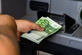 Depositor withdraws EURO from ATM cash money machine. Man hand holding EURO banknotes at the ATM machine Royalty Free Stock Photo