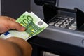 Depositor withdraws EURO from ATM cash money machine. Man hand holding EURO banknotes at the ATM machine Royalty Free Stock Photo