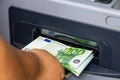 Depositor withdraws EURO from ATM cash money machine. Man hand holding EURO banknotes at the ATM machine Royalty Free Stock Photo