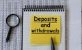 DEPOSITS and withdrawals - words in a white notebook on the background of a table with numbers and a magnifying glass