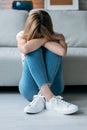 Depresive young woman thinking about her problems while sitting on the floor in the living room at home Royalty Free Stock Photo