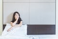 depress woman sitting on bed in room