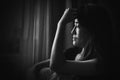 depress woman sitting on chair in room near window in white tone Royalty Free Stock Photo