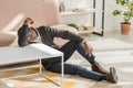 African american man leaning on table while sitting on floor at home Royalty Free Stock Photo