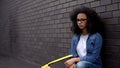 Depressed african teenager sitting school backyard feeling lonely, difficulties