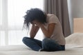 Depressed african woman sitting alone in bed