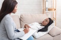 Depressed afro woman discussing her problems with psychotherapist at personal consultation Royalty Free Stock Photo