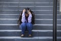 Depressed Asian American student woman or bullied teenager sitting outdoors on street staircase overwhelmed and anxious feeling Royalty Free Stock Photo