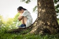 Depressed asian child girl was sitting alone crying and thinking about problems at park,sad female teenage having psychological