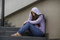 Depressed Asian Chinese student woman or bullied teenager girl sitting outdoors on street staircase victim of bullying feeling Royalty Free Stock Photo