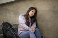 Depressed Asian Korean student woman or bullied teenager sitting outdoors on street staircase overwhelmed and anxious feeling