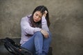 Depressed Asian Korean student woman or bullied teenager sitting outdoors on street staircase overwhelmed and anxious feeling Royalty Free Stock Photo