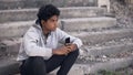 Depressed black college student listening smartphone music, emotional isolation