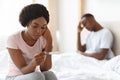 Depressed black woman holding pregnancy test, unintended pregnancy concept
