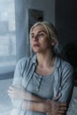 depressed blonde woman looking at window