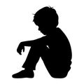 Depressed boy silhouette. Side profile portrait sitting on ground