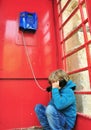 Depressed boy in telephone box