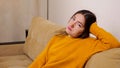 Depressed brunette with long loose flowing hair sits on sofa