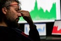 Depressed businessman in front of computer with graph of unsuccessful business on the screen