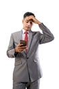 depressed businessman holding his forehead while using his mobile phone Royalty Free Stock Photo