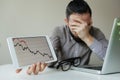 Depressed businessman leaning head below bad stock market chart Royalty Free Stock Photo