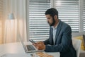 Depressed businessman man counting euro money working on computer at office desk, using smartphone , inflation concept. Royalty Free Stock Photo