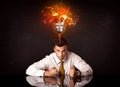 Businessman sitting under a blowing idea bulb Royalty Free Stock Photo