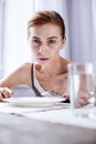 Depressed cheerless woman having breakfast