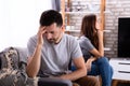 Depressed Couple Sitting On Sofa