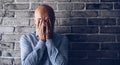 Crying man in front of the grey brick wall during finacial crisis Royalty Free Stock Photo