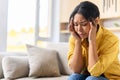 Depressed dark-skinned woman feels sad, offended, upset girl holding temples with her hands