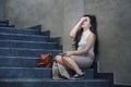 Depressed and desperate Asian Chinese businesswoman crying alone sitting on street staircase suffering stress and depression