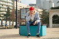 Depressed desperated guy hipster with phone sitting on bench in city having problems troubles. Royalty Free Stock Photo