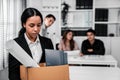 Sad employee packing her belongings after being fired for not being competent.