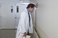 Depressed Doctor Leaning Against Wall