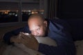 Depressed elderly black man. African American people using a smartphone on social media internet and sleeping on bed in bedroom at Royalty Free Stock Photo