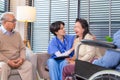 Depressed elderly female crying, young nurse consoling her at retirement home. Unhappy impaired man feeling lonely and sad Royalty Free Stock Photo