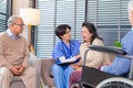 Depressed elderly female crying, young nurse consoling her at retirement home. Unhappy impaired man feeling lonely and sad Royalty Free Stock Photo