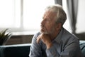 Depressed elderly man lost in thoughts mourning at home